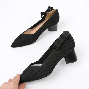 Close-up detail of black knitted bow shoe accessory decoration on elegant high-heeled pump