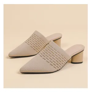 Detailed close-up of beige pointed-toe knit mule heels with breathable hollow pattern