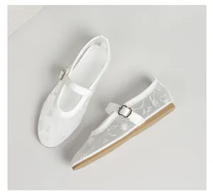 Close-up of white breathable mesh Mary Jane shoes with delicate floral embroidery details