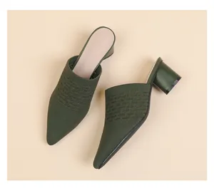 Detailed shot of dark green pointed-toe knit mules featuring breathable texture and chunky heels