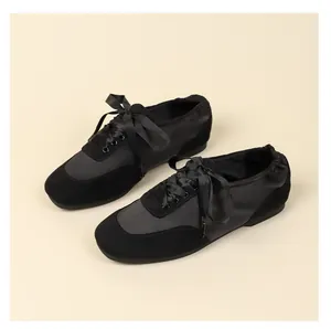 Detailed view of elegant black satin ribbon lace-up ballet flats with soft suede