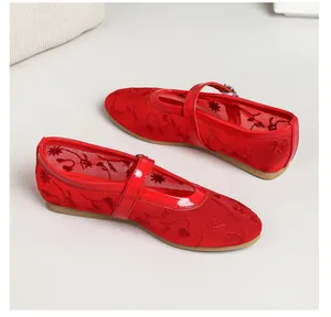 Detailed macro view of red floral embroidery on breathable mesh Mary Jane flat shoes.