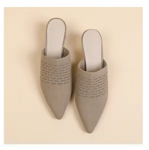Detailed close-up of elegant breathable knitted pointed-toe chunky heel mules in beige