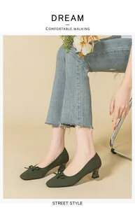 Close-up of dark green knitted square toe pumps with bow and chunky heel