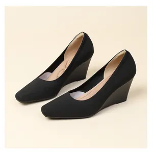 Detailed view of the breathable black knit upper and wedge heel on these pumps.