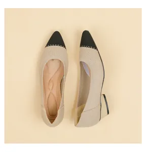 Vista detallada de zapatos de salón de punto beige con punta negra y tacón de bloque