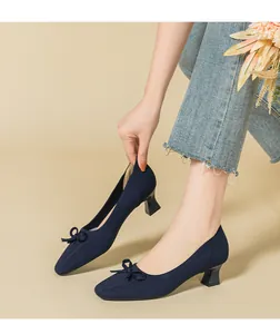 Close-up of navy blue knitted pumps with a stylish square toe and elegant bow detail.