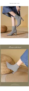 Detail view of grey pointed-toe knit ankle boots with elegant flared high heels.