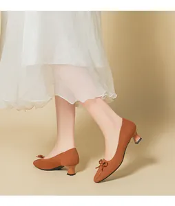 Close-up of brown knitted square-toe pumps with bow detail and block heels