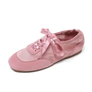 Women's pink satin and suede ballet flats featuring elegant ribbon lace-up design