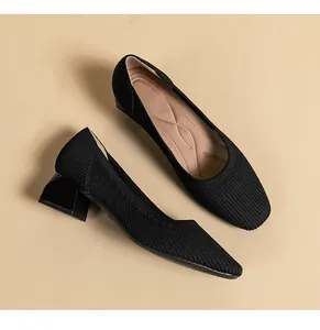 Primo piano di scarpe in maglia traspirante nera con elegante tacco largo e punta quadrata