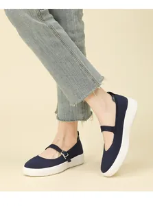 Detailed on-foot view of women's navy blue fly-knit Mary Jane shoes with thick white soles.