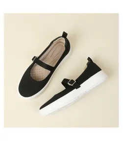Close-up of black breathable knit Mary Jane shoes with white sole and buckle strap