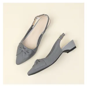Vista detallada de la elegante textura de punto gris y el lazo en estos zapatos de punta