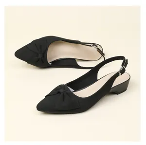 Primer plano de zapatos destalonados negros de punto con punta y lazo decorativo