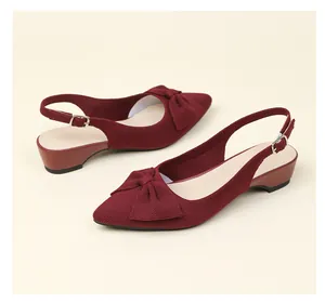 Vista detallada de elegantes zapatos destalonados de punto granate con lazo grande