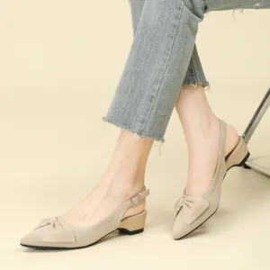 Sandalias slingback de punto beige con punta fina, lazo y cuña baja estilo francés.