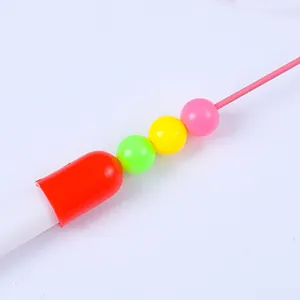 Primer plano de cuentas de plástico de colores en un juguete de varita para gatos de cable