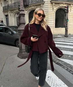 Model draagt een bordeauxrode wollen jas in Franse stijl op een Parijs zebrapad-straat