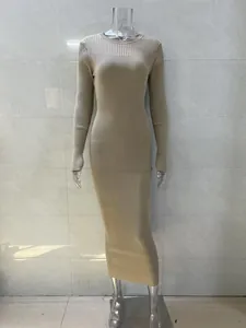 Close-up of elegant beige ribbed knit long sleeve maxi dress showing refined texture