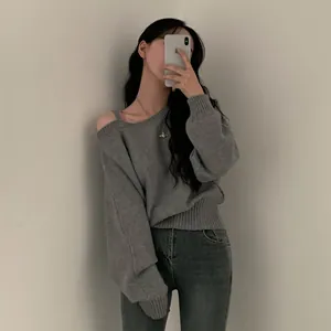 Maglione in maglia grigio con spalle scoperte, vestibilità comoda e stile casual autunnale.