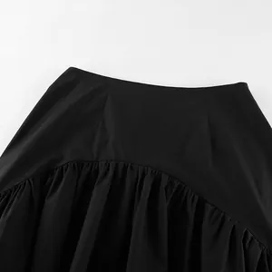 Close-up detail of a French style black high waist skirt with ruffled asymmetrical design.