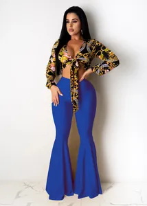 Close-up of a floral patterned tie-front crop top paired with blue flared pants.
