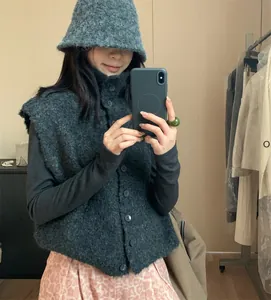 Vue détaillée d'un gilet en maille bouclée gris anthracite à col montant et boutons.