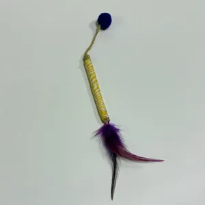 Close-up of matatabi cat chew stick toy with vibrant purple feathers and blue pom-pom