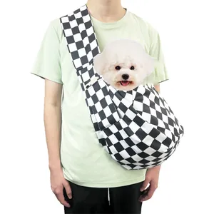 Portable black and white checkerboard pet carrier sling bag worn by a model for small dogs