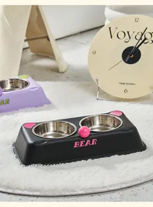 Modern stainless steel double pet bowl with cute cartoon bear design on a white soft rug