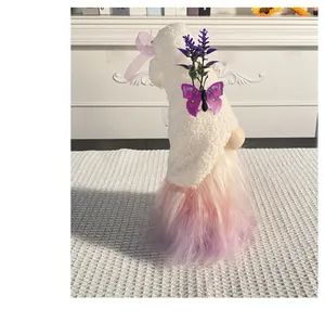Detail of plush gnome figurine with butterfly and lavender decoration on white hat.