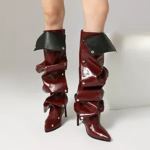 Detail von burgunderroten Stiletto-Stiefeln mit Rüschendesign und Metallnieten.