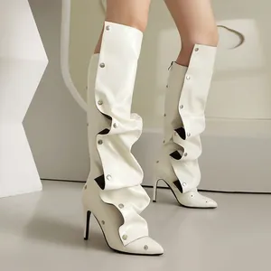 Detail von weißen Pant-Leg-Stiefeln mit Nieten, spitzer Zehenpartie und Stiletto-Absätzen