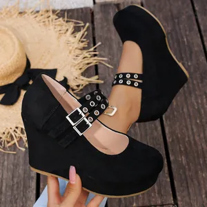 Primer plano de zapatos de cuña de ante negro con correas de hebilla de metal doble