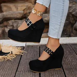 Vista de detalle de zapatos de cuña en ante negro con correas de hebilla doble