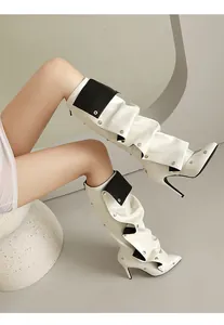 Detailansicht weißer spitzer Stiefel mit hohen Absätzen, Nieten und schwarzen Klappen