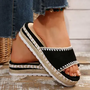 Zwarte sleehak sandalen met jute vlechtwerk details en wit geborduurde randen.