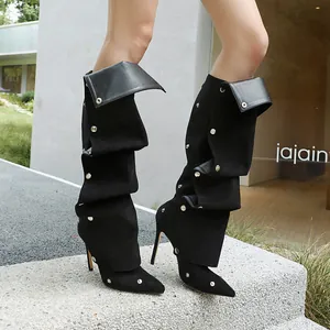 Seitenansicht der schwarzen spitzen Slouch-Stiefel mit silbernen Nietendetails.