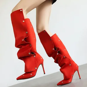 Detail von roten spitzen Stiefeln mit silbernen Nieten und hohen Stiletto-Absätzen.