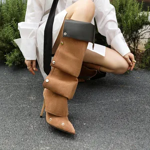 Detailaufnahme der braunen Veloursleder-Stilettostiefel mit schwarzer Manschette und Nieten.