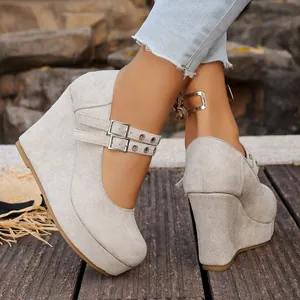 Vista detallada de zapatos de cuña con plataforma en ante gris y hebillas de corazón