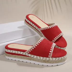 Gedetailleerde weergave van rode suède dames sleehaksandalen met geweven touw