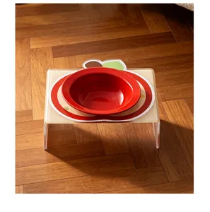 Dettaglio di una ciotola in ceramica rossa con supporto in acrilico a forma di mela