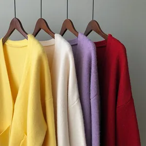 Detailed view of loose V-neck knitted cardigans in yellow, beige, purple, and red.