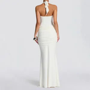 Elegant white halter neck floor-length dress with backless design and ruching.