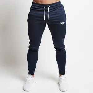 Close-up of navy blue slim fit athletic joggers showing white drawstring and side stripes