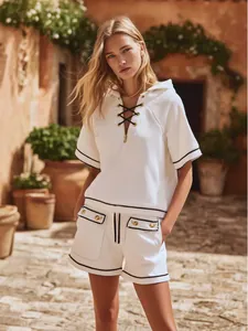 Detailed view of stylish white ribbed knit resort two-piece set worn by model in a sunny setting.