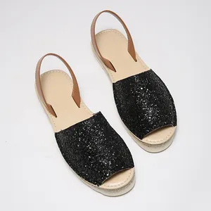 Detail view of black glitter peep-toe sandals with comfortable brown heel strap.