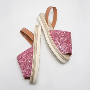 Close-up of pink glitter peep-toe sandals with stylish straw-trimmed thick sole